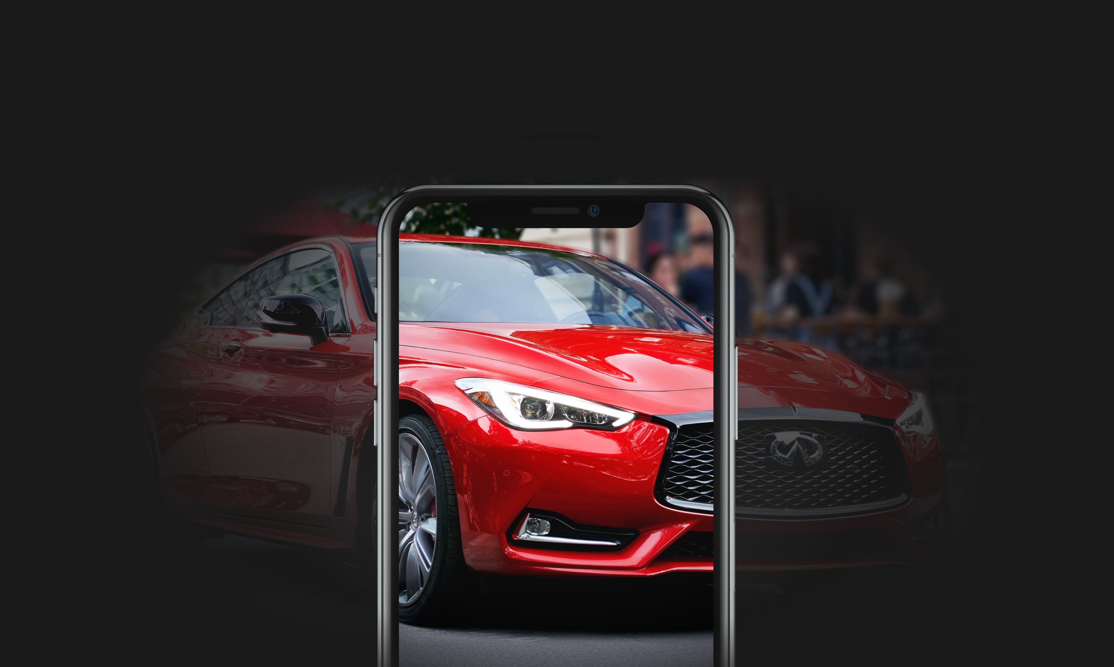 Avant d’un coupé sport Q60 rouge vu au moyen d’un écran de téléphone sur fond noir.