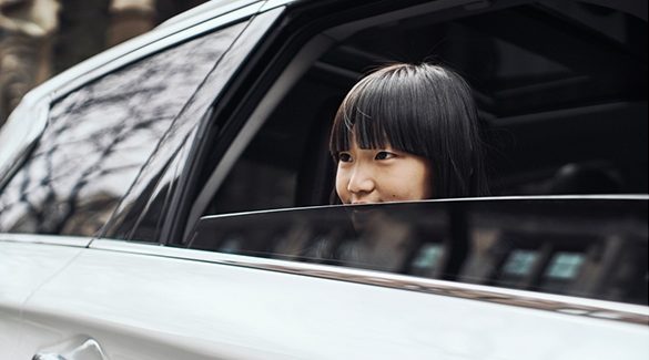 Un enfant regardant par la lunette arrière d’un véhicule INFINITI