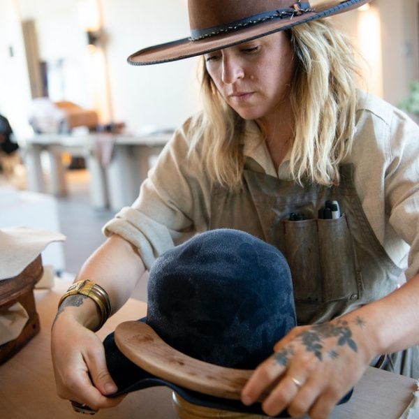 Keryn Nicholson de la Keryn Nicholson Hat Company travaillant à la confection d’un chapeau bleu.