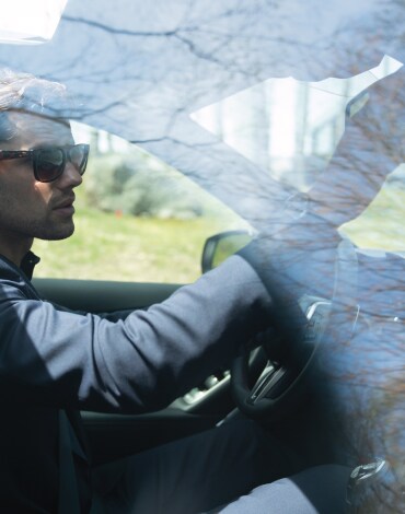 Man adjusting rearview mirror in his 2023 INFINITI Q50