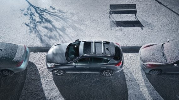 Une vue en plongée de l’INFINITI EX35 stationné en parallèle entre deux voitures couvertes de neige